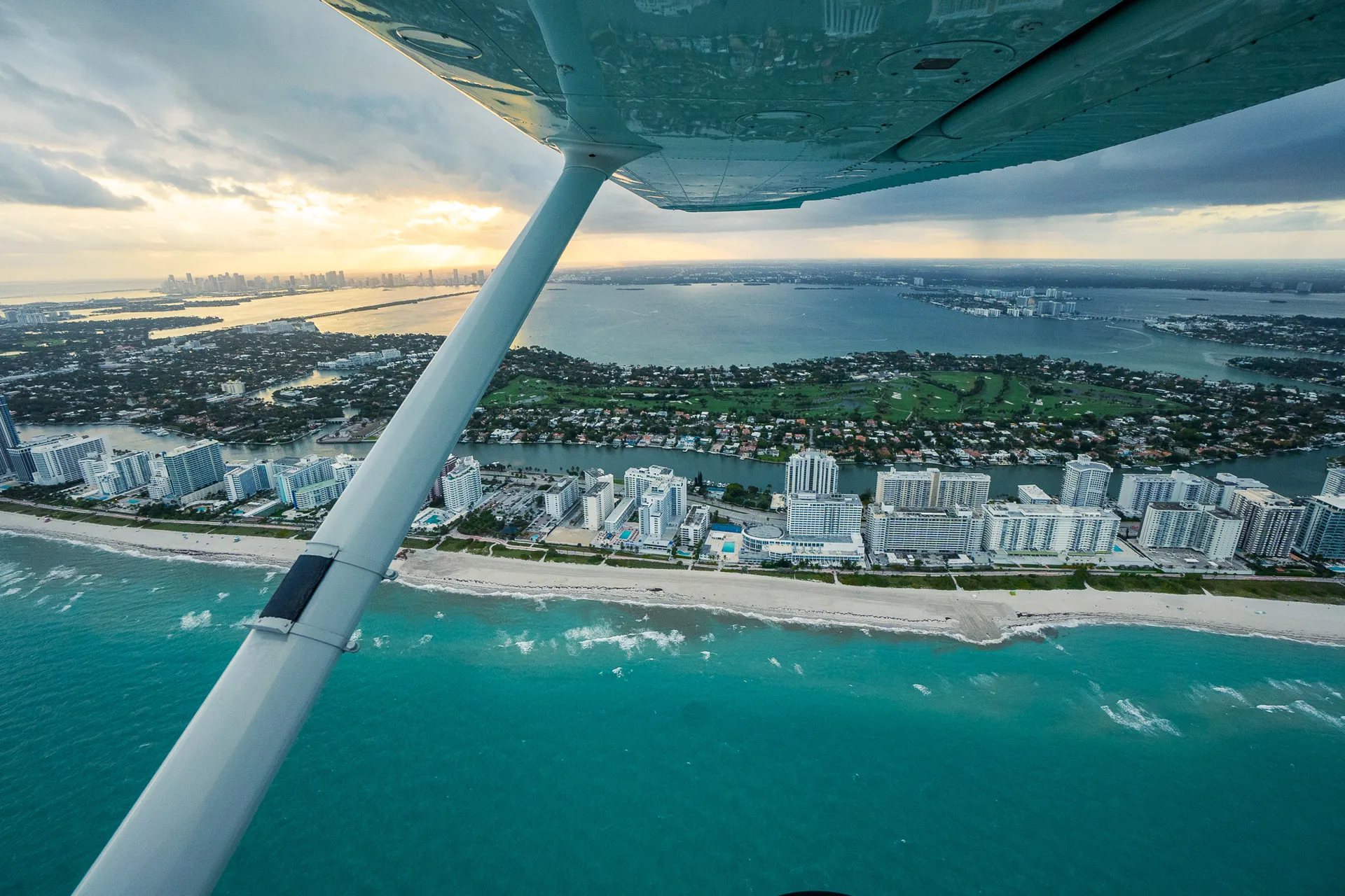 sun city aviation academy airplane flying over the city of miami