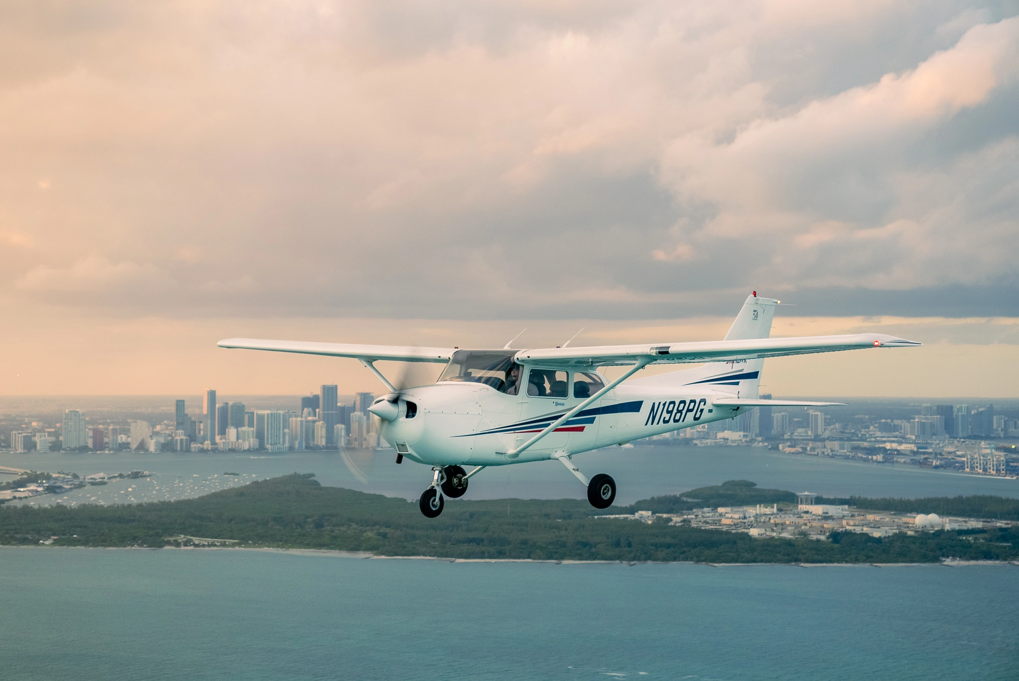 Sun City Aviation Academy student flying a plane over the city of Miami