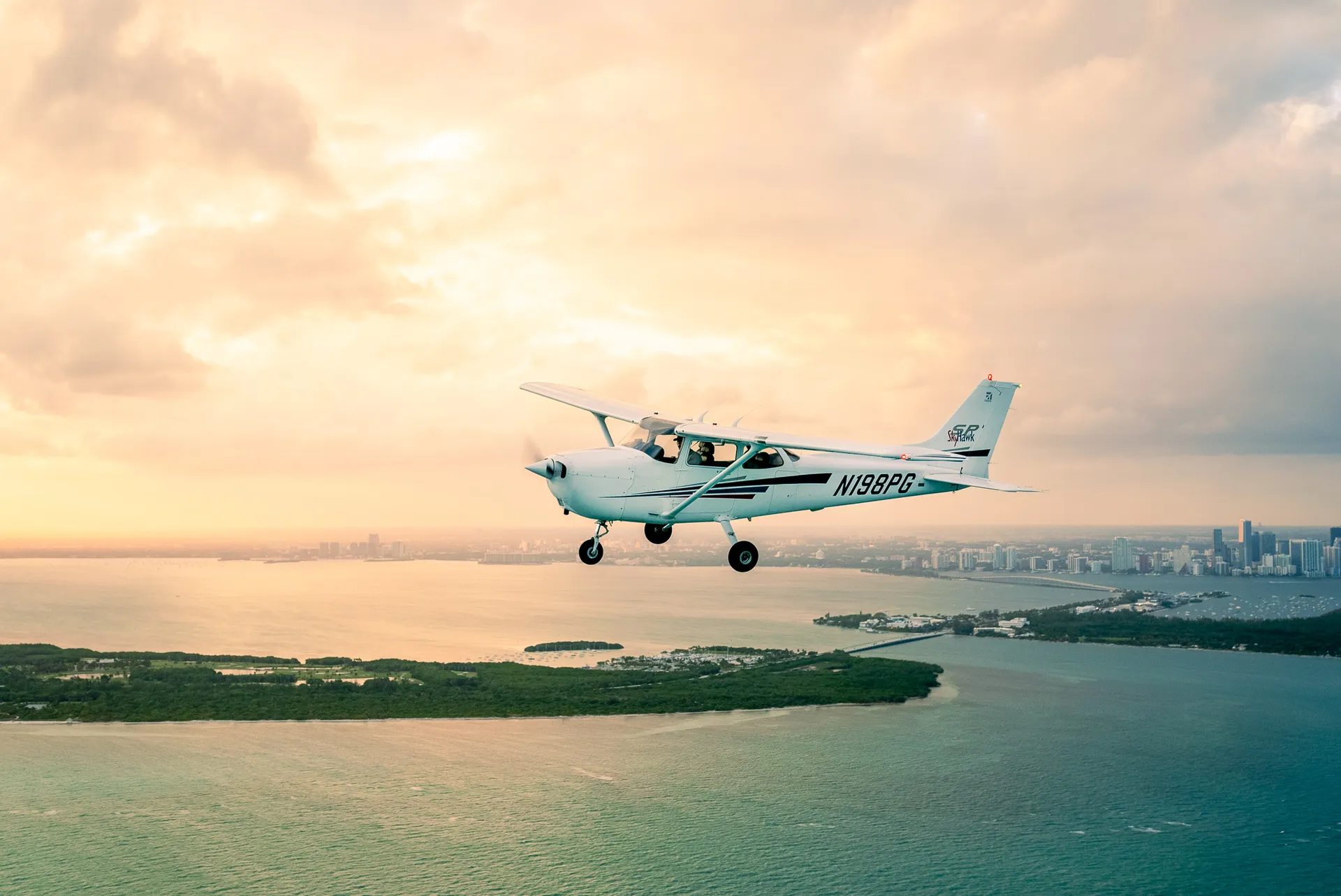 sun city aviation academy student flying a plane over the sunset