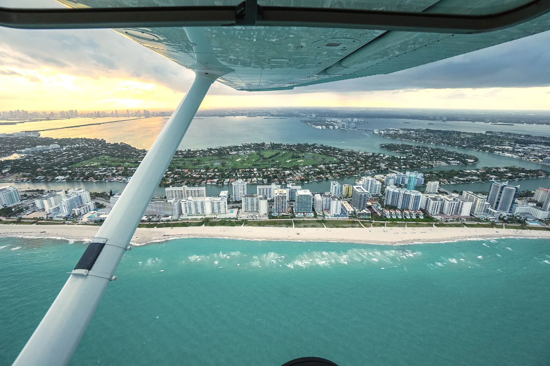 sun city aviation academy airplane flying over the city of miami