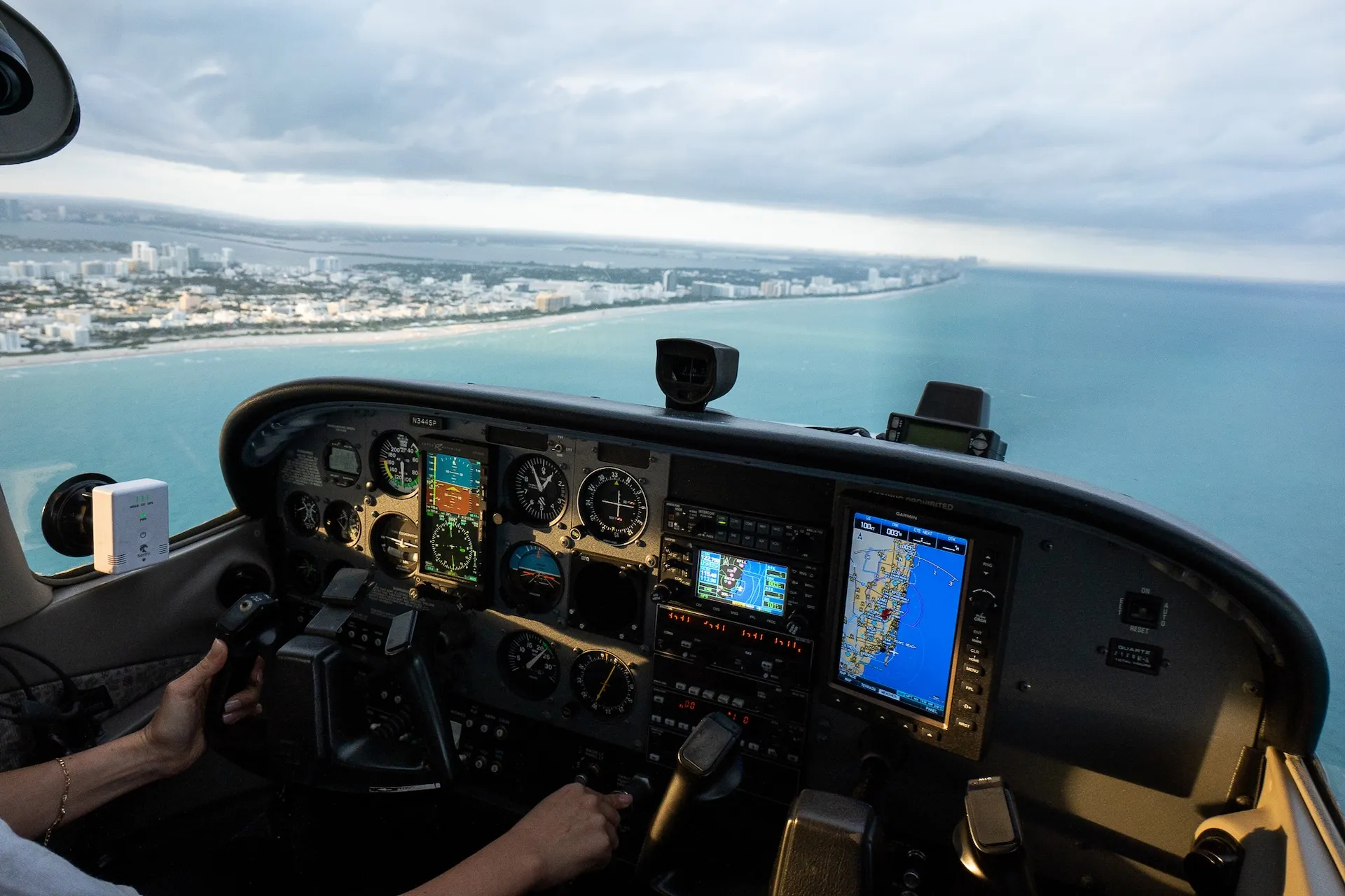 sun city aviation academy airplane flying over the city of miami