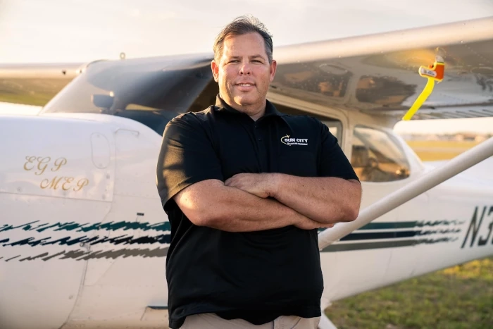 sun city aviation founder luke poulos in front of a sun city airplane