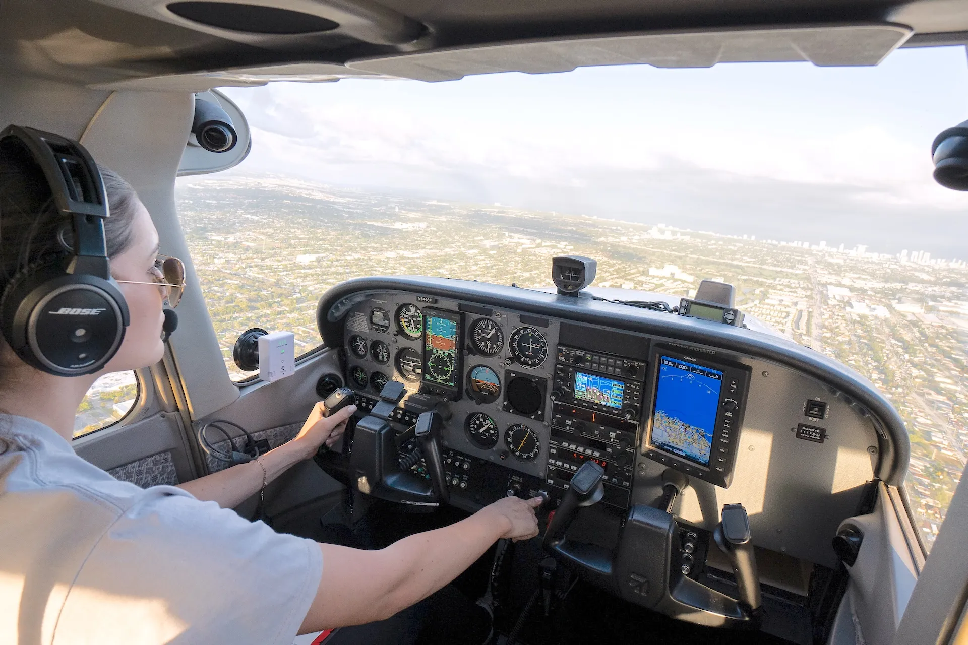 sun city aviation academy airplane flying over the city of miami