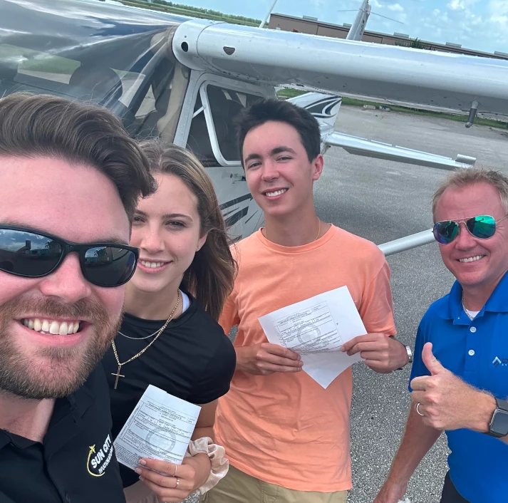 Students, examiner, and CFI after a checkride taking a selfie at Sun City Aviation Academy