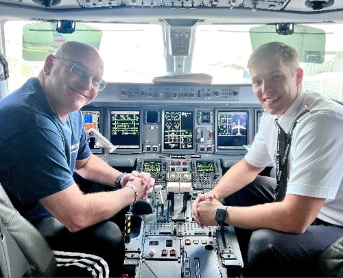 Sun City team member and alumni inside airliner cockpit